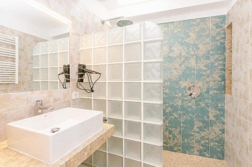 ein Bad mit einem Waschbecken und einer Dusche in der Unterkunft Townhouse with puig de María view by home villas 360 in Pollença
