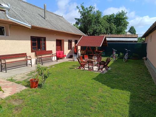 um quintal com uma mesa e cadeiras e um gazebo em Kiskastély Apartman em Balmazújváros