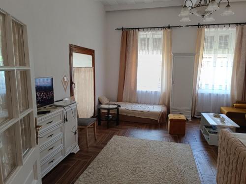 a small living room with a bed and a dresser at Kiskastély Apartman in Balmazújváros