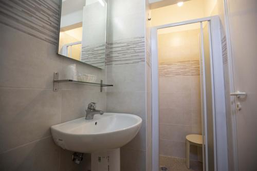 a bathroom with a sink and a mirror and a shower at Hotel Explorer in Cervia