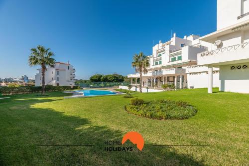 a view of the yard of a building with a swimming pool at #071 Spacious Seaview with Pool, Tennis Court and AC in Albufeira
