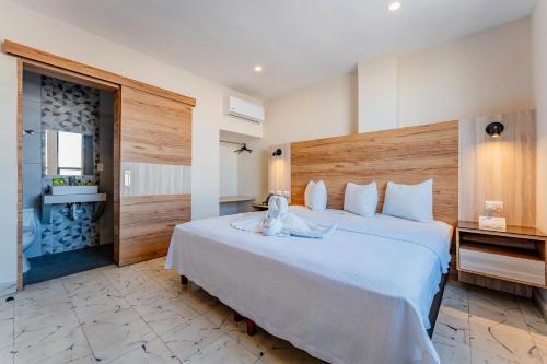 a hotel room with a bed with a stuffed animal on it at Hotel Central Merida by Kavia in Mérida