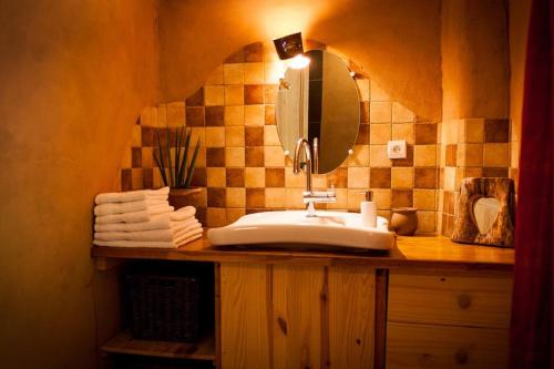 La salle de bains est pourvue d'un lavabo et d'un miroir. dans l'établissement Le Nid des Anges, à Saint-André-Lachamp