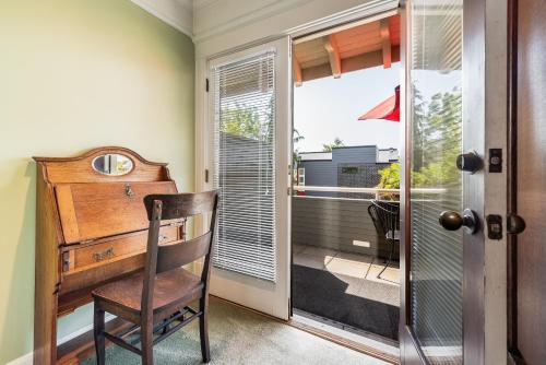 Cette chambre dispose d'un bureau en bois et d'une fenêtre. dans l'établissement Seattle Gaslight Inn, à Seattle