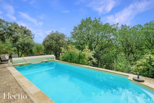 una piscina con un banco y árboles en Mas du Rocher I Electio, en Puget