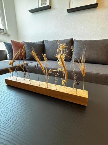 a couch with some plants on a wooden table at Modernes Apartment in Stadionnähe in Gelsenkirchen