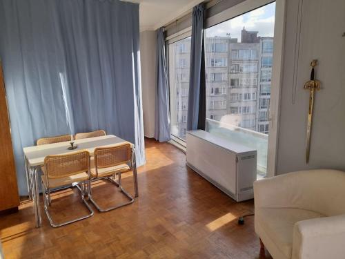 a living room with a table and chairs and a large window at Sunny in Antwerp