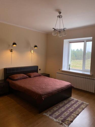 a bedroom with a bed and a window at Opushka in Vorobʼyëvka