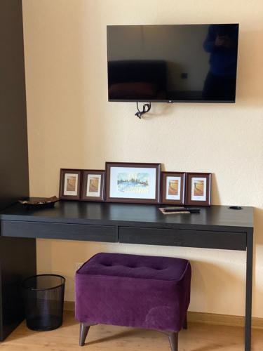 a table with a purple ottoman under a tv at Opushka in Vorobʼyëvka