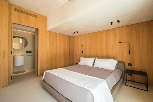 1 dormitorio con 1 cama grande y paredes de madera en Calitro Mare, en Torre Ovo