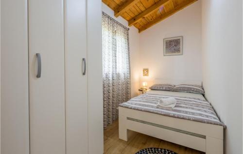 a small bedroom with a bed and a window at 2 Bedroom Awesome Home In Loborika in Loborika