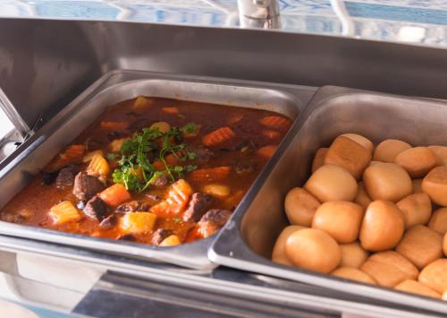 two trays of food with potatoes and meat and stew at Minh Chau Pearl Hotel & Spa - Quan Lan Island in Quang Ninh