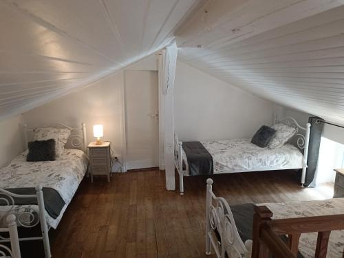 a bedroom with two beds in a attic at Gîte du Tilleul 6 pers - Au Clos de Parranquet in Parranquet