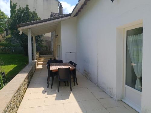 a patio with a table and chairs next to a building at Gîte du Tilleul 6 pers - Au Clos de Parranquet in Parranquet