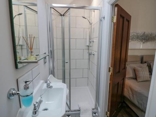 a bathroom with a shower and a sink and a mirror at The Nest in Nuneaton