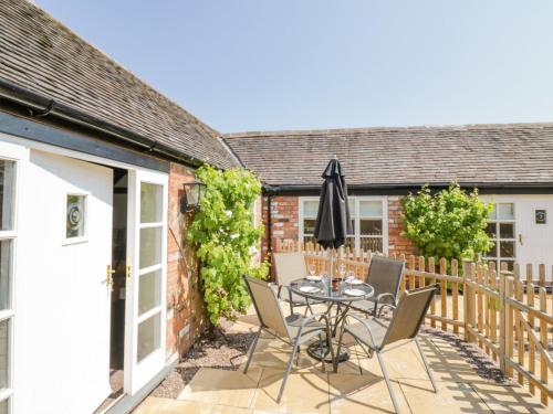 a patio with a table and chairs in front of a house at The Nest in Nuneaton