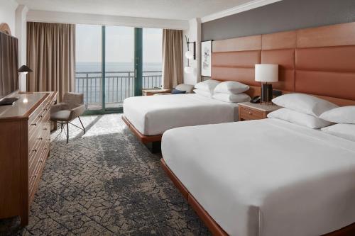 Habitación de hotel con 2 camas y balcón en Sheraton Oceanfront Hotel, en Virginia Beach