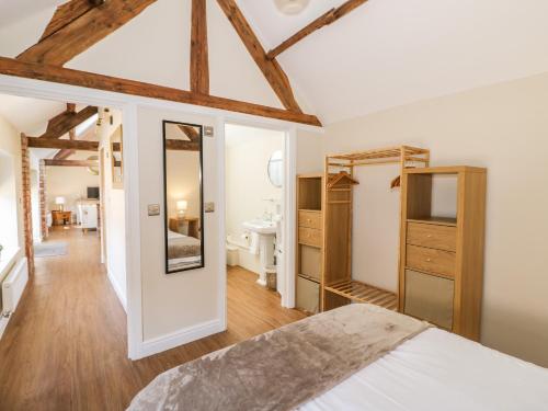 a bedroom with a white bed and a bathroom at The Dairy in Nuneaton