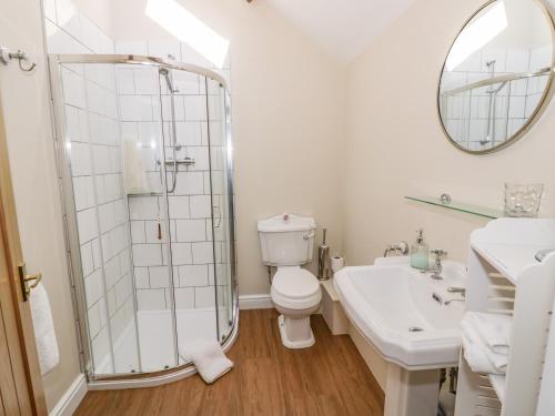 a bathroom with a shower and a toilet and a sink at The Dairy in Nuneaton