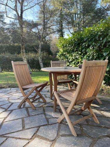 une table en bois, 2 chaises, une table et des chaises dans l'établissement Le Rosa: Villa de charme entre mer et pinède, à Quend