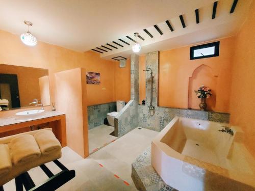 a large bathroom with a tub and a sink at Retro Box Hotel Chumphon in Chumphon