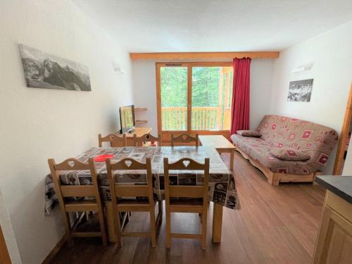 un salon avec une table, des chaises et un canapé dans l'établissement CosyRefuges - Le Refuge des Marmottes, à Vars