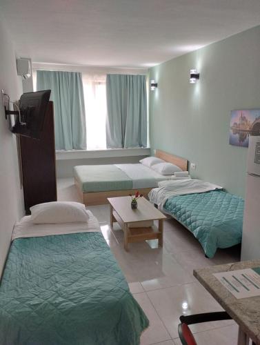 a hospital room with three beds and a table at Menta Studios in Thessaloniki