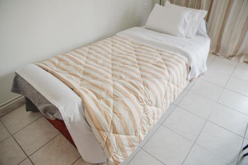 a bed with a white comforter on it in a room at SOSEA in Alexandroupoli