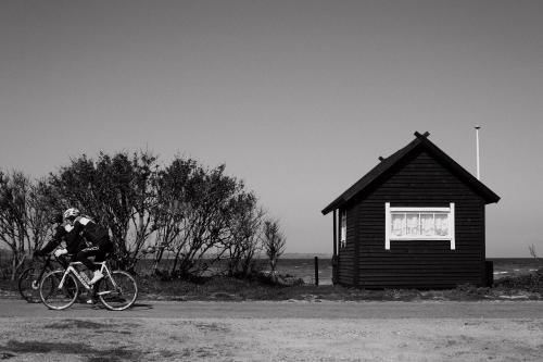 een man die fietst naast een klein gebouw bij Aggershøj pensionat in Marstal