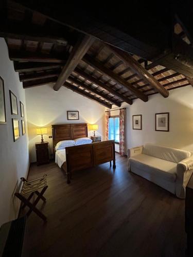 a bedroom with a bed and a couch in a room at Hotel Conti Formentini in San Floriano del Cóllio