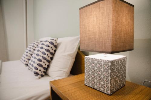 a bed with a table with a lamp and a pillow at SOSEA in Alexandroupoli