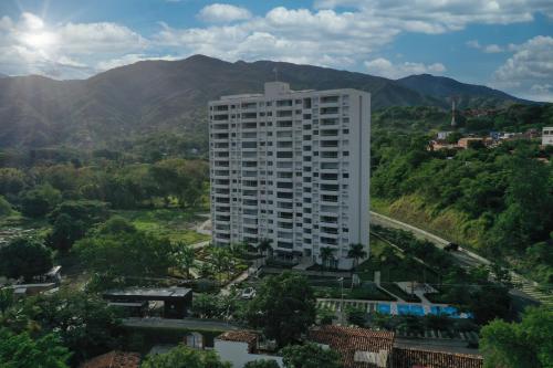 a tall white building with mountains in the background at Stunning, Brand-new Apartment in Santa Fe de Antioquia