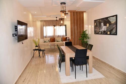 a dining room and living room with a table and chairs at RAWAN RESIDENCY in Oujda