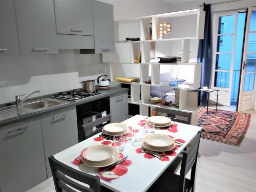 a kitchen with a table with plates and glasses on it at Alba House in Cuneo