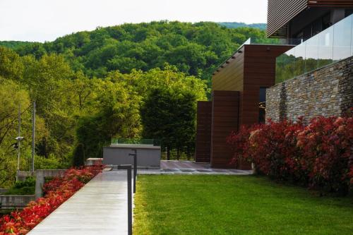 a garden with a wooden walkway next to a building at #SKGH Arbitrage Hyperluxe Villa -near Pozar Baths & Kaimaktsalan mountain in Sarakinoí