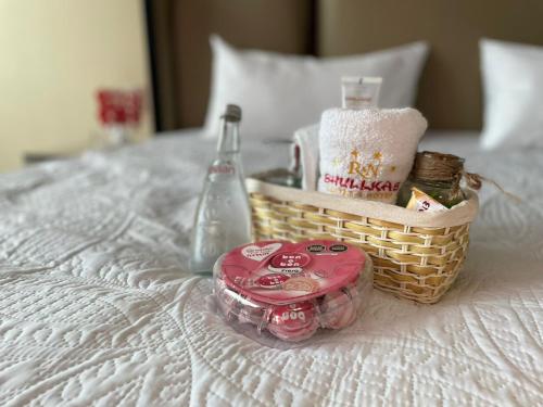 a basket with a drink and a bottle on a bed at R&N SHULLKAS SUITES in Huancayo