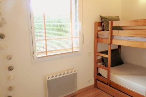 Cette petite chambre comprend des lits superposés et une fenêtre. dans l'établissement Le GLAZ * Grande plage & commerces à pied * Jardin, à Carnac