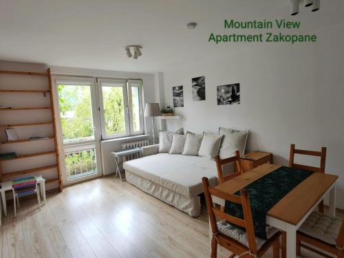 ザコパネにあるMountain View Apartment Zakopaneのベッドルーム1室(ベッド1台、テーブル、テーブルサイドシックスシックス付)