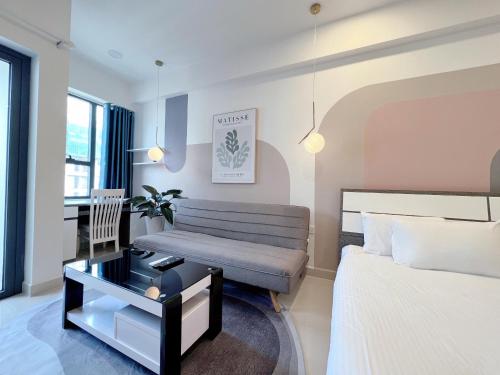 Un dormitorio con una cama, un sofá y una mesa. en jessica' 1 bed studio condo in canter, en Ho Chi Minh