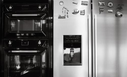 two refrigerators with magnets on them next to a refrigerator at #SKGH Arbitrage Hyperluxe Villa -near Pozar Baths & Kaimaktsalan mountain in Sarakinoí