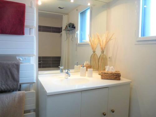 a white bathroom with a sink and a mirror at Le GLAZ * Grande plage & commerces à pied * Jardin in Carnac