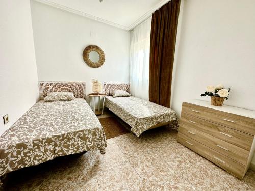 トレビエハにあるBungalow Parque Nacionesのベッドルーム1室(ベッド2台、鏡付)