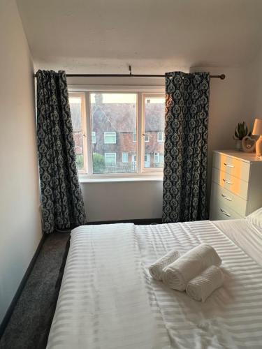a bedroom with a bed with two pillows and a window at Nano Rooms Accommodation in Coventry