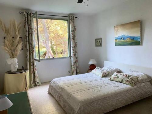 een slaapkamer met een groot bed en een raam bij MasAupellière la petite Camargue in Vauvert