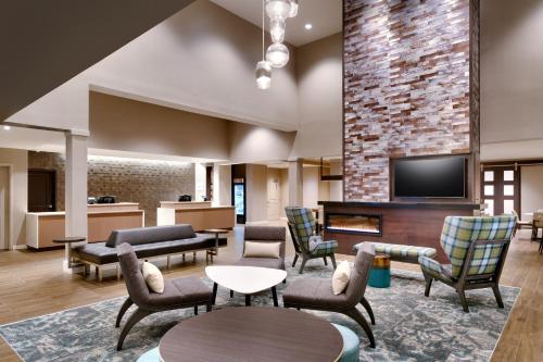 a living room with a fireplace and chairs at Residence Inn by Marriott Brunswick in Brunswick
