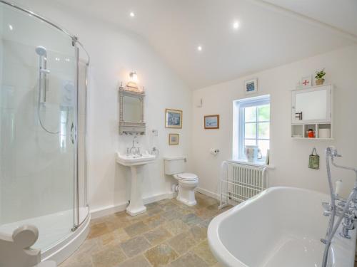 a bathroom with a tub and a toilet and a sink at Ty Het in Llanfairpwllgwyngyll