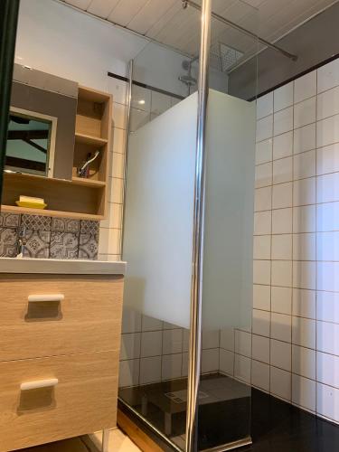 La salle de bains est pourvue d'une douche en verre et de carrelage blanc. dans l'établissement La maison de Mamie, à Pessac