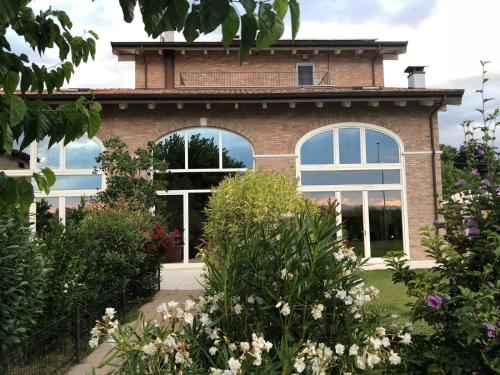 a house with windows and flowers in front of it at R&B Il Melograno in Formigine