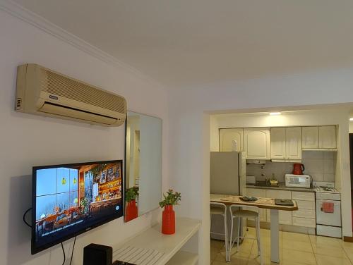 a living room with a flat screen tv on a wall at MENDOZA Suites 8 in Mendoza