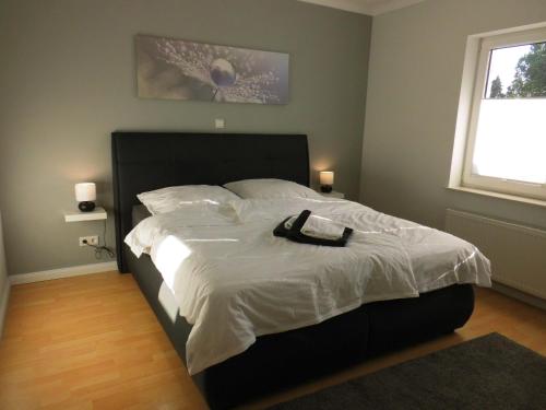 ein Schlafzimmer mit einem großen Bett mit schwarzem Kopfteil in der Unterkunft Haus Holldack Wohnung Maria in Goldenstedt